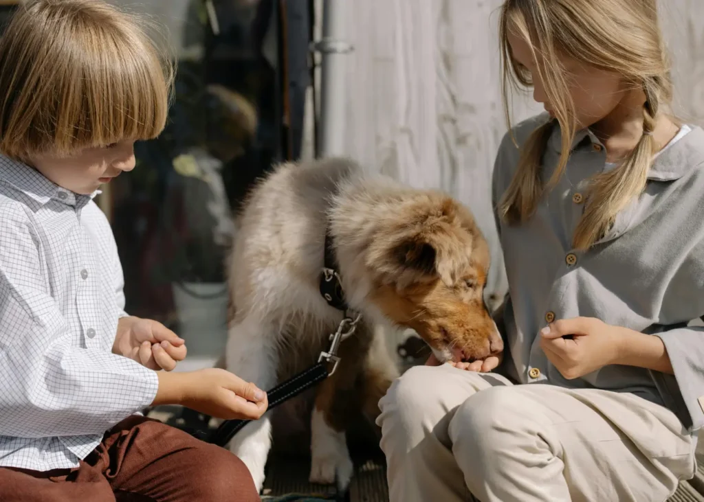 two children petting a young dog